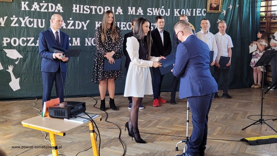 Zakończenie roku szkolnego 2021/2022 w Katolickim Liceum Ogólnokształcącym W piątek, 29 kwietnia 2022 roku, w całej Polsce uczniowie klas maturalnych szkół ponadpodstawowych zakończyli edukację. Przed nimi za kilka dni już tylko egzamin dojrzałości. Tego dnia we wszystkich tomaszowskich szkołach ponadpodstawowych odbywały się uroczystości, podczas których wręczone zostały nagrody dla najlepszych uczniów, którzy wyróżnili się wysokimi wynikami w nauce i dla wszystkich maturzystów świadectwa ukończenia szkoły. W Katolickim Liceum Ogólnokształcącym w Tomaszowie Mazowieckim w zakończeniu roku szkolnego 2021/2022 udział wziął Mariusz Węgrzynowski – Starosta Powiatu Tomaszowskiego, Włodzimierz Justyna – radny Rady Powiatu Tomaszowskiego, Marek Sarwa – Wicedyrektor KOWR w Łodzi. Wręczone zostały świadectwa. Uczniowie młodszych klas przygotowali program artystyczny. Uroczystość uświetnił także występ Stowarzyszenia Nadzieja, w składzie: Zuzanna Ignasiak, Weronika Bąk i Konrad Ignasiak. „Państwo Dyrektorzy, szanowne grono pedagogiczne, drodzy przyjaciele Szkół Katolickich, wszyscy, którzy są obecni, szanowni rodzice, przede wszystkim Wy, drodzy abiturienci. Pojawiła się radość w moim sercu słysząc wszystko to, co dzisiaj zostało przygotowane w ramach tej uroczystości, jak i też w ramach podsumowania Waszej trzyletniej nauki w Katolickim Liceum Ogólnokształcącym. Wychodząc z tej szkoły powinniście być wyjątkowymi ambasadorami tego wszystkiego, co wiąże się z katolicyzmem, czyli jest to system wartości - przede wszystkim pan Bóg, rodzina, ojczyzna, to wszystko było Waszym udziałem, to jest ta wartość dodana w ramach tej szkoły, w ramach tego kształcenia, która powinna się pojawić w Waszym życiu. To dekalog powinien być na pierwszym miejscu. 10 przykazań Bożych, które powinno iść z Wami przed Wami i powodować to, że będziecie wspaniałymi ludźmi, dobrymi ludźmi, tymi, którzy będą służyć też innym. Przychodziliście do tej szkoły, niektórzy sześć lat temu. Pamiętamy się jeszcze z pierwszej klasy. Są absolwenci Katolickiego Gimnazjum, kiedy patrzyliście tak nieśmiało w taką nutką niepewności, jak to będzie wyglądało, jak tutaj ta nauka będzie się odbywała? Czy spotkacie kolegów, koleżanki, takich, którzy będą Wam serdeczni, będą życzliwi z pełną wzajemnością do tych wszystkich działań, które będziecie podejmować. Takich kolegów i koleżanki spotkaliście. Spotkaliście wspaniałych nauczycieli. Te łzy wzruszenia, niewymuszone, które się pojawiły tutaj u pani dyrektor Sylwii Leszczuk i u pań, które emocjonalnie, z pełnym zaangażowaniem, z czystym sercem, które chciało, żebyście mogli naprawdę być szczęśliwi i zadowoleni, że jesteście tutaj. To wyznanie Marty jest czymś wyjątkowym. W pełni zaufała szkole, ale zaufała właśnie nauczycielom,  zaufała swoim koleżankom i kolegom. Dzisiaj wychodzicie z tej szkoły uformowani, dorośli ludzie, którzy już wiecie czego chcecie. Chcecie być dobrymi ludźmi, chcecie dawać tą miłość, którą tutaj sobie wypracowaliście, tą miłość, którą chce dzielić w swoim dorosłym życiu. To jest ta wyjątkowość tej szkoły, to jest coś wzruszającego, co nie przeżywamy na co dzień. Za to bardzo serdecznie jeszcze raz dziękuję dyrekcji, dziękuję nauczycielom, dziękuję przyjaciołom również Szkół Katolickich, którzy się angażują  w różnego rodzaju sprawy, które są związane z taką teraźniejszością, z tą działalnością, która jest poza murami szkoły, a też jest bardzo istotne i bardzo ważne, wspaniały występ Stowarzyszenia Nadzieja. Proszę Państwa, dwa dni temu, trzy dni temu, byliśmy świadkami występu tych młodych ludzi w Teatrze Wielkim w Łodzi przy obecności Wicepremiera Piotra Glińskiego, przy obecności Wicemarszałka Zbigniewa Ziemby, ale przy obecności. kilkuset ważnych ludzi. Zostali dostrzeżeni, nagrodzeni. Są ambasadorami Ziemi Tomaszowskiej. Dziękuję Wam bardzo, że chcieliście tutaj uświetnić swoim występem tą dzisiejszą uroczystość. W tych latach było patriotycznie, było sportowo, ale też ten duch człowieka, to odniesienie się do pana Boga było widoczne w codziennej działalności, w codziennym życiu. Wyjątkowi patroni szkoły. Niepokalane Serce Najświętszej Maryi Panny Królowej Korony Polskiej i Święty Ojciec Pio, którzy czuwają nad całą społecznością tych szkół pomimo, że warunki nie są tutaj wyjątkowo dobre, ale jednak atmosfera, która się wytworzyła w ramach tych szkół jest czymś wyjątkowym, czymś niepowtarzalnym. Te Wasze relacje pomiędzy sobą, one będą trwały przez całe życie i być może te więzi będą nawet ważniejsze niż inne, które  wypracujecie w dorosłym życiu to pozostanie, ale powtarzam raz jeszcze najważniejsze, żeby tą wartością dodaną, związaną z nauką w tej szkole było to, że będziecie dobrymi, prawymi ludźmi, nie tylko dla siebie, ale dla innych również, których spotkacie na swojej drodze i będziecie solą tej ziemi, Tomaszowskiej Ziemi. Będziecie dawać taki przykład, który spowoduje, że będziecie rozpoznawani jako abiturienci, absolwenci Szkół Katolickich. To powinno być Wasze główne zadanie, żeby w dorosłym życiu, mierząc się z różnymi trudnościami, zachować dalej to, co jest najważniejsze. O to Was bardzo serdecznie proszę. To będzie taki prawdziwy egzamin z tego wszystkiego, czego się tutaj nauczyliście. To będzie wspaniała satysfakcja dla nauczycieli i dla dyrekcji i dla członków Katolickiego Stowarzyszenia Oświatowego imieniem Świętego Ojca Pio, którzy działają po to, żeby wzmacniać tego ducha, żeby tych ludzi uczciwych i prawych było jak najwięcej w Tomaszowie, w powiecie, w całym kraju. Moi drodzy, bardzo serdecznie dziękuję wszystkim za te działania. Rzeczywiście to wzruszenie, które się pojawiło było wynikiem relacji wytworzonych przez te trzy czy też sześć lat, bo niektórzy troszeczkę dłużej spędzili niż te trzy lata w Katolickim Liceum Ogólnokształcącym. To jest coś wspaniałego, coś wyjątkowego. Gratuluję wszystkim, że ukończyliście tą szkołę, niektórzy z wyróżnieniem. To jest też wyjątkowa sytuacja. Średnia klasy wspaniała i mam taką nadzieję, przekonanie, że zdacie maturę, że będziecie mogli realizować swoje plany i cele, zamierzenia życiowe, które gdzieś tam są w Was, nieśmiało, ale są. Udało się zrealizować wiele tych celi, teraz kolejny etap, nie bójcie się, podejdźcie do tego z głęboką wiarą, że możecie iść dalej, dalej jeszcze dalej, co da Wam taką pewność siebie i otworzy nowe możliwości rozwoju osobowego, zawodowego. A w przyszłości również z tego wszystkiego, co wiąże się z życiem rodzinnym.  Moi drodzy, bardzo się cieszę, że jestem tutaj obecny dziś na tej uroczystości. Cieszę się razem z Wami mogę przeżywać ten moment ukończenia Katolickiego Liceum Ogólnokształcącego. I jeszcze raz Wam gratuluję wszystkim nauczycielom. Dziękuję członkom Katolickiego Stowarzyszenia Oświatowego imienia Świętego Ojca Pio, jak i również sympatykom Stowarzyszenia Szkół. Dziękuję za wszelką pomoc, która płynie każdego dnia. Jak sami Państwo widzicie, warto działać na rzecz tego, żeby takie Szkoły Katolickie na terenie naszego powiatu istniały. Życzę Wam wszystkiego dobrego. Szczęść Boże.” – powiedział Mariusz Węgrzynowski – Starosta Powiatu Tomaszowskiego. 