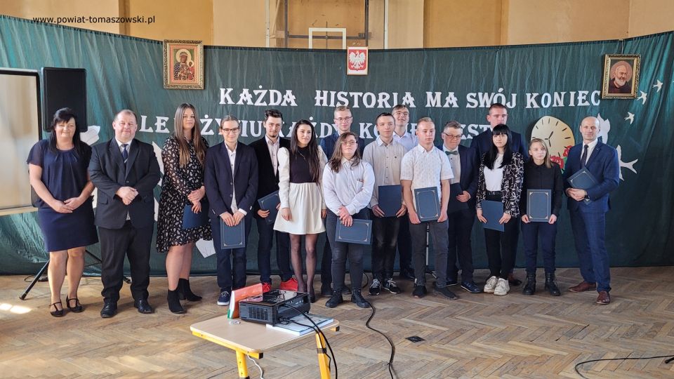 Zakończenie roku szkolnego 2021/2022 w Katolickim Liceum Ogólnokształcącym W piątek, 29 kwietnia 2022 roku, w całej Polsce uczniowie klas maturalnych szkół ponadpodstawowych zakończyli edukację. Przed nimi za kilka dni już tylko egzamin dojrzałości. Tego dnia we wszystkich tomaszowskich szkołach ponadpodstawowych odbywały się uroczystości, podczas których wręczone zostały nagrody dla najlepszych uczniów, którzy wyróżnili się wysokimi wynikami w nauce i dla wszystkich maturzystów świadectwa ukończenia szkoły. W Katolickim Liceum Ogólnokształcącym w Tomaszowie Mazowieckim w zakończeniu roku szkolnego 2021/2022 udział wziął Mariusz Węgrzynowski – Starosta Powiatu Tomaszowskiego, Włodzimierz Justyna – radny Rady Powiatu Tomaszowskiego, Marek Sarwa – Wicedyrektor KOWR w Łodzi. Wręczone zostały świadectwa. Uczniowie młodszych klas przygotowali program artystyczny. Uroczystość uświetnił także występ Stowarzyszenia Nadzieja, w składzie: Zuzanna Ignasiak, Weronika Bąk i Konrad Ignasiak. „Państwo Dyrektorzy, szanowne grono pedagogiczne, drodzy przyjaciele Szkół Katolickich, wszyscy, którzy są obecni, szanowni rodzice, przede wszystkim Wy, drodzy abiturienci. Pojawiła się radość w moim sercu słysząc wszystko to, co dzisiaj zostało przygotowane w ramach tej uroczystości, jak i też w ramach podsumowania Waszej trzyletniej nauki w Katolickim Liceum Ogólnokształcącym. Wychodząc z tej szkoły powinniście być wyjątkowymi ambasadorami tego wszystkiego, co wiąże się z katolicyzmem, czyli jest to system wartości - przede wszystkim pan Bóg, rodzina, ojczyzna, to wszystko było Waszym udziałem, to jest ta wartość dodana w ramach tej szkoły, w ramach tego kształcenia, która powinna się pojawić w Waszym życiu. To dekalog powinien być na pierwszym miejscu. 10 przykazań Bożych, które powinno iść z Wami przed Wami i powodować to, że będziecie wspaniałymi ludźmi, dobrymi ludźmi, tymi, którzy będą służyć też innym. Przychodziliście do tej szkoły, niektórzy sześć lat temu. Pamiętamy się jeszcze z pierwszej klasy. Są absolwenci Katolickiego Gimnazjum, kiedy patrzyliście tak nieśmiało w taką nutką niepewności, jak to będzie wyglądało, jak tutaj ta nauka będzie się odbywała? Czy spotkacie kolegów, koleżanki, takich, którzy będą Wam serdeczni, będą życzliwi z pełną wzajemnością do tych wszystkich działań, które będziecie podejmować. Takich kolegów i koleżanki spotkaliście. Spotkaliście wspaniałych nauczycieli. Te łzy wzruszenia, niewymuszone, które się pojawiły tutaj u pani dyrektor Sylwii Leszczuk i u pań, które emocjonalnie, z pełnym zaangażowaniem, z czystym sercem, które chciało, żebyście mogli naprawdę być szczęśliwi i zadowoleni, że jesteście tutaj. To wyznanie Marty jest czymś wyjątkowym. W pełni zaufała szkole, ale zaufała właśnie nauczycielom,  zaufała swoim koleżankom i kolegom. Dzisiaj wychodzicie z tej szkoły uformowani, dorośli ludzie, którzy już wiecie czego chcecie. Chcecie być dobrymi ludźmi, chcecie dawać tą miłość, którą tutaj sobie wypracowaliście, tą miłość, którą chce dzielić w swoim dorosłym życiu. To jest ta wyjątkowość tej szkoły, to jest coś wzruszającego, co nie przeżywamy na co dzień. Za to bardzo serdecznie jeszcze raz dziękuję dyrekcji, dziękuję nauczycielom, dziękuję przyjaciołom również Szkół Katolickich, którzy się angażują  w różnego rodzaju sprawy, które są związane z taką teraźniejszością, z tą działalnością, która jest poza murami szkoły, a też jest bardzo istotne i bardzo ważne, wspaniały występ Stowarzyszenia Nadzieja. Proszę Państwa, dwa dni temu, trzy dni temu, byliśmy świadkami występu tych młodych ludzi w Teatrze Wielkim w Łodzi przy obecności Wicepremiera Piotra Glińskiego, przy obecności Wicemarszałka Zbigniewa Ziemby, ale przy obecności. kilkuset ważnych ludzi. Zostali dostrzeżeni, nagrodzeni. Są ambasadorami Ziemi Tomaszowskiej. Dziękuję Wam bardzo, że chcieliście tutaj uświetnić swoim występem tą dzisiejszą uroczystość. W tych latach było patriotycznie, było sportowo, ale też ten duch człowieka, to odniesienie się do pana Boga było widoczne w codziennej działalności, w codziennym życiu. Wyjątkowi patroni szkoły. Niepokalane Serce Najświętszej Maryi Panny Królowej Korony Polskiej i Święty Ojciec Pio, którzy czuwają nad całą społecznością tych szkół pomimo, że warunki nie są tutaj wyjątkowo dobre, ale jednak atmosfera, która się wytworzyła w ramach tych szkół jest czymś wyjątkowym, czymś niepowtarzalnym. Te Wasze relacje pomiędzy sobą, one będą trwały przez całe życie i być może te więzi będą nawet ważniejsze niż inne, które  wypracujecie w dorosłym życiu to pozostanie, ale powtarzam raz jeszcze najważniejsze, żeby tą wartością dodaną, związaną z nauką w tej szkole było to, że będziecie dobrymi, prawymi ludźmi, nie tylko dla siebie, ale dla innych również, których spotkacie na swojej drodze i będziecie solą tej ziemi, Tomaszowskiej Ziemi. Będziecie dawać taki przykład, który spowoduje, że będziecie rozpoznawani jako abiturienci, absolwenci Szkół Katolickich. To powinno być Wasze główne zadanie, żeby w dorosłym życiu, mierząc się z różnymi trudnościami, zachować dalej to, co jest najważniejsze. O to Was bardzo serdecznie proszę. To będzie taki prawdziwy egzamin z tego wszystkiego, czego się tutaj nauczyliście. To będzie wspaniała satysfakcja dla nauczycieli i dla dyrekcji i dla członków Katolickiego Stowarzyszenia Oświatowego imieniem Świętego Ojca Pio, którzy działają po to, żeby wzmacniać tego ducha, żeby tych ludzi uczciwych i prawych było jak najwięcej w Tomaszowie, w powiecie, w całym kraju. Moi drodzy, bardzo serdecznie dziękuję wszystkim za te działania. Rzeczywiście to wzruszenie, które się pojawiło było wynikiem relacji wytworzonych przez te trzy czy też sześć lat, bo niektórzy troszeczkę dłużej spędzili niż te trzy lata w Katolickim Liceum Ogólnokształcącym. To jest coś wspaniałego, coś wyjątkowego. Gratuluję wszystkim, że ukończyliście tą szkołę, niektórzy z wyróżnieniem. To jest też wyjątkowa sytuacja. Średnia klasy wspaniała i mam taką nadzieję, przekonanie, że zdacie maturę, że będziecie mogli realizować swoje plany i cele, zamierzenia życiowe, które gdzieś tam są w Was, nieśmiało, ale są. Udało się zrealizować wiele tych celi, teraz kolejny etap, nie bójcie się, podejdźcie do tego z głęboką wiarą, że możecie iść dalej, dalej jeszcze dalej, co da Wam taką pewność siebie i otworzy nowe możliwości rozwoju osobowego, zawodowego. A w przyszłości również z tego wszystkiego, co wiąże się z życiem rodzinnym.  Moi drodzy, bardzo się cieszę, że jestem tutaj obecny dziś na tej uroczystości. Cieszę się razem z Wami mogę przeżywać ten moment ukończenia Katolickiego Liceum Ogólnokształcącego. I jeszcze raz Wam gratuluję wszystkim nauczycielom. Dziękuję członkom Katolickiego Stowarzyszenia Oświatowego imienia Świętego Ojca Pio, jak i również sympatykom Stowarzyszenia Szkół. Dziękuję za wszelką pomoc, która płynie każdego dnia. Jak sami Państwo widzicie, warto działać na rzecz tego, żeby takie Szkoły Katolickie na terenie naszego powiatu istniały. Życzę Wam wszystkiego dobrego. Szczęść Boże.” – powiedział Mariusz Węgrzynowski – Starosta Powiatu Tomaszowskiego. 