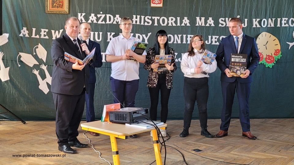 Zakończenie roku szkolnego 2021/2022 w Katolickim Liceum Ogólnokształcącym W piątek, 29 kwietnia 2022 roku, w całej Polsce uczniowie klas maturalnych szkół ponadpodstawowych zakończyli edukację. Przed nimi za kilka dni już tylko egzamin dojrzałości. Tego dnia we wszystkich tomaszowskich szkołach ponadpodstawowych odbywały się uroczystości, podczas których wręczone zostały nagrody dla najlepszych uczniów, którzy wyróżnili się wysokimi wynikami w nauce i dla wszystkich maturzystów świadectwa ukończenia szkoły. W Katolickim Liceum Ogólnokształcącym w Tomaszowie Mazowieckim w zakończeniu roku szkolnego 2021/2022 udział wziął Mariusz Węgrzynowski – Starosta Powiatu Tomaszowskiego, Włodzimierz Justyna – radny Rady Powiatu Tomaszowskiego, Marek Sarwa – Wicedyrektor KOWR w Łodzi. Wręczone zostały świadectwa. Uczniowie młodszych klas przygotowali program artystyczny. Uroczystość uświetnił także występ Stowarzyszenia Nadzieja, w składzie: Zuzanna Ignasiak, Weronika Bąk i Konrad Ignasiak. „Państwo Dyrektorzy, szanowne grono pedagogiczne, drodzy przyjaciele Szkół Katolickich, wszyscy, którzy są obecni, szanowni rodzice, przede wszystkim Wy, drodzy abiturienci. Pojawiła się radość w moim sercu słysząc wszystko to, co dzisiaj zostało przygotowane w ramach tej uroczystości, jak i też w ramach podsumowania Waszej trzyletniej nauki w Katolickim Liceum Ogólnokształcącym. Wychodząc z tej szkoły powinniście być wyjątkowymi ambasadorami tego wszystkiego, co wiąże się z katolicyzmem, czyli jest to system wartości - przede wszystkim pan Bóg, rodzina, ojczyzna, to wszystko było Waszym udziałem, to jest ta wartość dodana w ramach tej szkoły, w ramach tego kształcenia, która powinna się pojawić w Waszym życiu. To dekalog powinien być na pierwszym miejscu. 10 przykazań Bożych, które powinno iść z Wami przed Wami i powodować to, że będziecie wspaniałymi ludźmi, dobrymi ludźmi, tymi, którzy będą służyć też innym. Przychodziliście do tej szkoły, niektórzy sześć lat temu. Pamiętamy się jeszcze z pierwszej klasy. Są absolwenci Katolickiego Gimnazjum, kiedy patrzyliście tak nieśmiało w taką nutką niepewności, jak to będzie wyglądało, jak tutaj ta nauka będzie się odbywała? Czy spotkacie kolegów, koleżanki, takich, którzy będą Wam serdeczni, będą życzliwi z pełną wzajemnością do tych wszystkich działań, które będziecie podejmować. Takich kolegów i koleżanki spotkaliście. Spotkaliście wspaniałych nauczycieli. Te łzy wzruszenia, niewymuszone, które się pojawiły tutaj u pani dyrektor Sylwii Leszczuk i u pań, które emocjonalnie, z pełnym zaangażowaniem, z czystym sercem, które chciało, żebyście mogli naprawdę być szczęśliwi i zadowoleni, że jesteście tutaj. To wyznanie Marty jest czymś wyjątkowym. W pełni zaufała szkole, ale zaufała właśnie nauczycielom,  zaufała swoim koleżankom i kolegom. Dzisiaj wychodzicie z tej szkoły uformowani, dorośli ludzie, którzy już wiecie czego chcecie. Chcecie być dobrymi ludźmi, chcecie dawać tą miłość, którą tutaj sobie wypracowaliście, tą miłość, którą chce dzielić w swoim dorosłym życiu. To jest ta wyjątkowość tej szkoły, to jest coś wzruszającego, co nie przeżywamy na co dzień. Za to bardzo serdecznie jeszcze raz dziękuję dyrekcji, dziękuję nauczycielom, dziękuję przyjaciołom również Szkół Katolickich, którzy się angażują  w różnego rodzaju sprawy, które są związane z taką teraźniejszością, z tą działalnością, która jest poza murami szkoły, a też jest bardzo istotne i bardzo ważne, wspaniały występ Stowarzyszenia Nadzieja. Proszę Państwa, dwa dni temu, trzy dni temu, byliśmy świadkami występu tych młodych ludzi w Teatrze Wielkim w Łodzi przy obecności Wicepremiera Piotra Glińskiego, przy obecności Wicemarszałka Zbigniewa Ziemby, ale przy obecności. kilkuset ważnych ludzi. Zostali dostrzeżeni, nagrodzeni. Są ambasadorami Ziemi Tomaszowskiej. Dziękuję Wam bardzo, że chcieliście tutaj uświetnić swoim występem tą dzisiejszą uroczystość. W tych latach było patriotycznie, było sportowo, ale też ten duch człowieka, to odniesienie się do pana Boga było widoczne w codziennej działalności, w codziennym życiu. Wyjątkowi patroni szkoły. Niepokalane Serce Najświętszej Maryi Panny Królowej Korony Polskiej i Święty Ojciec Pio, którzy czuwają nad całą społecznością tych szkół pomimo, że warunki nie są tutaj wyjątkowo dobre, ale jednak atmosfera, która się wytworzyła w ramach tych szkół jest czymś wyjątkowym, czymś niepowtarzalnym. Te Wasze relacje pomiędzy sobą, one będą trwały przez całe życie i być może te więzi będą nawet ważniejsze niż inne, które  wypracujecie w dorosłym życiu to pozostanie, ale powtarzam raz jeszcze najważniejsze, żeby tą wartością dodaną, związaną z nauką w tej szkole było to, że będziecie dobrymi, prawymi ludźmi, nie tylko dla siebie, ale dla innych również, których spotkacie na swojej drodze i będziecie solą tej ziemi, Tomaszowskiej Ziemi. Będziecie dawać taki przykład, który spowoduje, że będziecie rozpoznawani jako abiturienci, absolwenci Szkół Katolickich. To powinno być Wasze główne zadanie, żeby w dorosłym życiu, mierząc się z różnymi trudnościami, zachować dalej to, co jest najważniejsze. O to Was bardzo serdecznie proszę. To będzie taki prawdziwy egzamin z tego wszystkiego, czego się tutaj nauczyliście. To będzie wspaniała satysfakcja dla nauczycieli i dla dyrekcji i dla członków Katolickiego Stowarzyszenia Oświatowego imieniem Świętego Ojca Pio, którzy działają po to, żeby wzmacniać tego ducha, żeby tych ludzi uczciwych i prawych było jak najwięcej w Tomaszowie, w powiecie, w całym kraju. Moi drodzy, bardzo serdecznie dziękuję wszystkim za te działania. Rzeczywiście to wzruszenie, które się pojawiło było wynikiem relacji wytworzonych przez te trzy czy też sześć lat, bo niektórzy troszeczkę dłużej spędzili niż te trzy lata w Katolickim Liceum Ogólnokształcącym. To jest coś wspaniałego, coś wyjątkowego. Gratuluję wszystkim, że ukończyliście tą szkołę, niektórzy z wyróżnieniem. To jest też wyjątkowa sytuacja. Średnia klasy wspaniała i mam taką nadzieję, przekonanie, że zdacie maturę, że będziecie mogli realizować swoje plany i cele, zamierzenia życiowe, które gdzieś tam są w Was, nieśmiało, ale są. Udało się zrealizować wiele tych celi, teraz kolejny etap, nie bójcie się, podejdźcie do tego z głęboką wiarą, że możecie iść dalej, dalej jeszcze dalej, co da Wam taką pewność siebie i otworzy nowe możliwości rozwoju osobowego, zawodowego. A w przyszłości również z tego wszystkiego, co wiąże się z życiem rodzinnym.  Moi drodzy, bardzo się cieszę, że jestem tutaj obecny dziś na tej uroczystości. Cieszę się razem z Wami mogę przeżywać ten moment ukończenia Katolickiego Liceum Ogólnokształcącego. I jeszcze raz Wam gratuluję wszystkim nauczycielom. Dziękuję członkom Katolickiego Stowarzyszenia Oświatowego imienia Świętego Ojca Pio, jak i również sympatykom Stowarzyszenia Szkół. Dziękuję za wszelką pomoc, która płynie każdego dnia. Jak sami Państwo widzicie, warto działać na rzecz tego, żeby takie Szkoły Katolickie na terenie naszego powiatu istniały. Życzę Wam wszystkiego dobrego. Szczęść Boże.” – powiedział Mariusz Węgrzynowski – Starosta Powiatu Tomaszowskiego. 