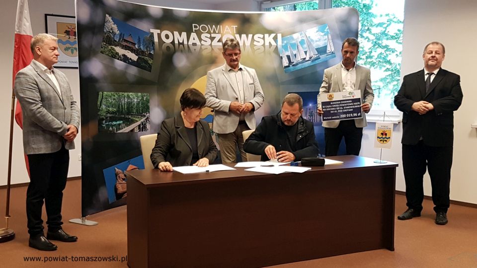 Na zdjęciu: od prawej stoją: Mariusz Węgrzynowski – Starosta Powiatu Tomaszowskiego, Marek Kubiak – członek Zarządu Powiatu Tomaszowskiego, Leszek Ogórek – Wicestarosta Powiatu Tomaszowskiego, Tomasz Zdonek – radny Rady Powiatu Tomaszowskiego, siedzą - Elżbieta Rudzka – dyrektor Zarządu Dróg Powiatowych i Grzegorz Więckowski – współwłaściciel Firmy „Dromed” Rospędek, Więckowski, podczas podpisania umowy na realizację zadania pod nazwą: Budowa chodnika w ciągu drogi powiatowej 4327E na odcinku od ul. Starowiejskiej do ul. Pod Grotami Na zdjęciu: od prawej stoją: Mariusz Węgrzynowski – Starosta Powiatu Tomaszowskiego, Marek Kubiak – członek Zarządu Powiatu Tomaszowskiego, Leszek Ogórek – Wicestarosta Powiatu Tomaszowskiego, Tomasz Zdonek – radny Rady Powiatu Tomaszowskiego, siedzą - Elżbieta Rudzka – dyrektor Zarządu Dróg Powiatowych i Grzegorz Więckowski – współwłaściciel Firmy „Dromed” Rospędek, Więckowski, podczas podpisania umowy na realizację zadania pod nazwą: Budowa chodnika w ciągu drogi powiatowej 4327E na odcinku od ul. Starowiejskiej do ul. Pod Grotami