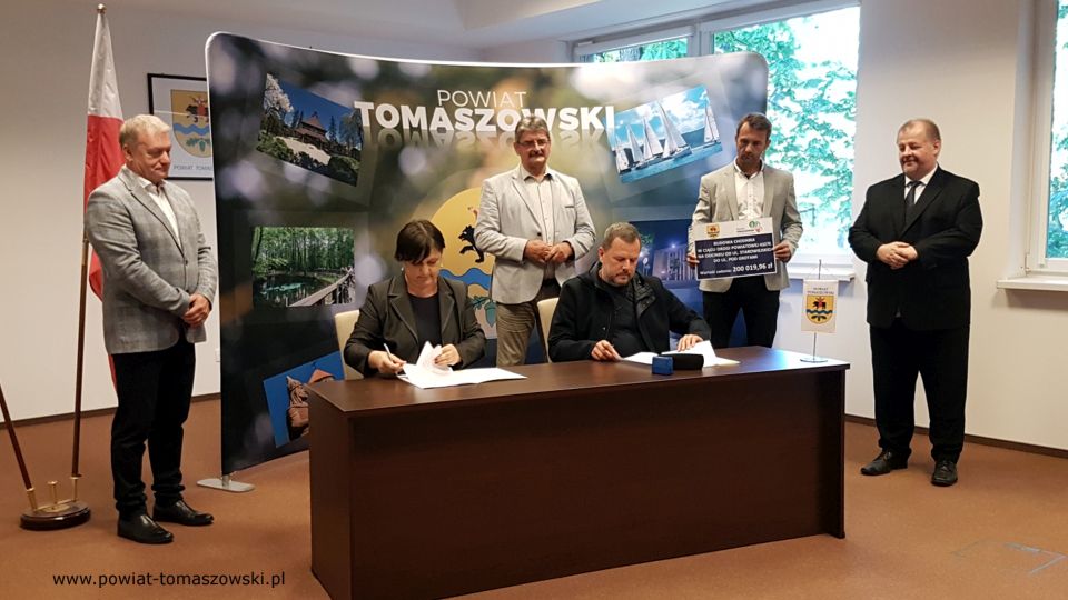 Na zdjęciu: od prawej stoją: Mariusz Węgrzynowski – Starosta Powiatu Tomaszowskiego, Marek Kubiak – członek Zarządu Powiatu Tomaszowskiego, Leszek Ogórek – Wicestarosta Powiatu Tomaszowskiego, Tomasz Zdonek – radny Rady Powiatu Tomaszowskiego, siedzą - Elżbieta Rudzka – dyrektor Zarządu Dróg Powiatowych i Grzegorz Więckowski – współwłaściciel Firmy „Dromed” Rospędek, Więckowski, podczas podpisania umowy na realizację zadania pod nazwą: Budowa chodnika w ciągu drogi powiatowej 4327E na odcinku od ul. Starowiejskiej do ul. Pod Grotami Na zdjęciu: od prawej stoją: Mariusz Węgrzynowski – Starosta Powiatu Tomaszowskiego, Marek Kubiak – członek Zarządu Powiatu Tomaszowskiego, Leszek Ogórek – Wicestarosta Powiatu Tomaszowskiego, Tomasz Zdonek – radny Rady Powiatu Tomaszowskiego, siedzą - Elżbieta Rudzka – dyrektor Zarządu Dróg Powiatowych i Grzegorz Więckowski – współwłaściciel Firmy „Dromed” Rospędek, Więckowski, podczas podpisania umowy na realizację zadania pod nazwą: Budowa chodnika w ciągu drogi powiatowej 4327E na odcinku od ul. Starowiejskiej do ul. Pod Grotami