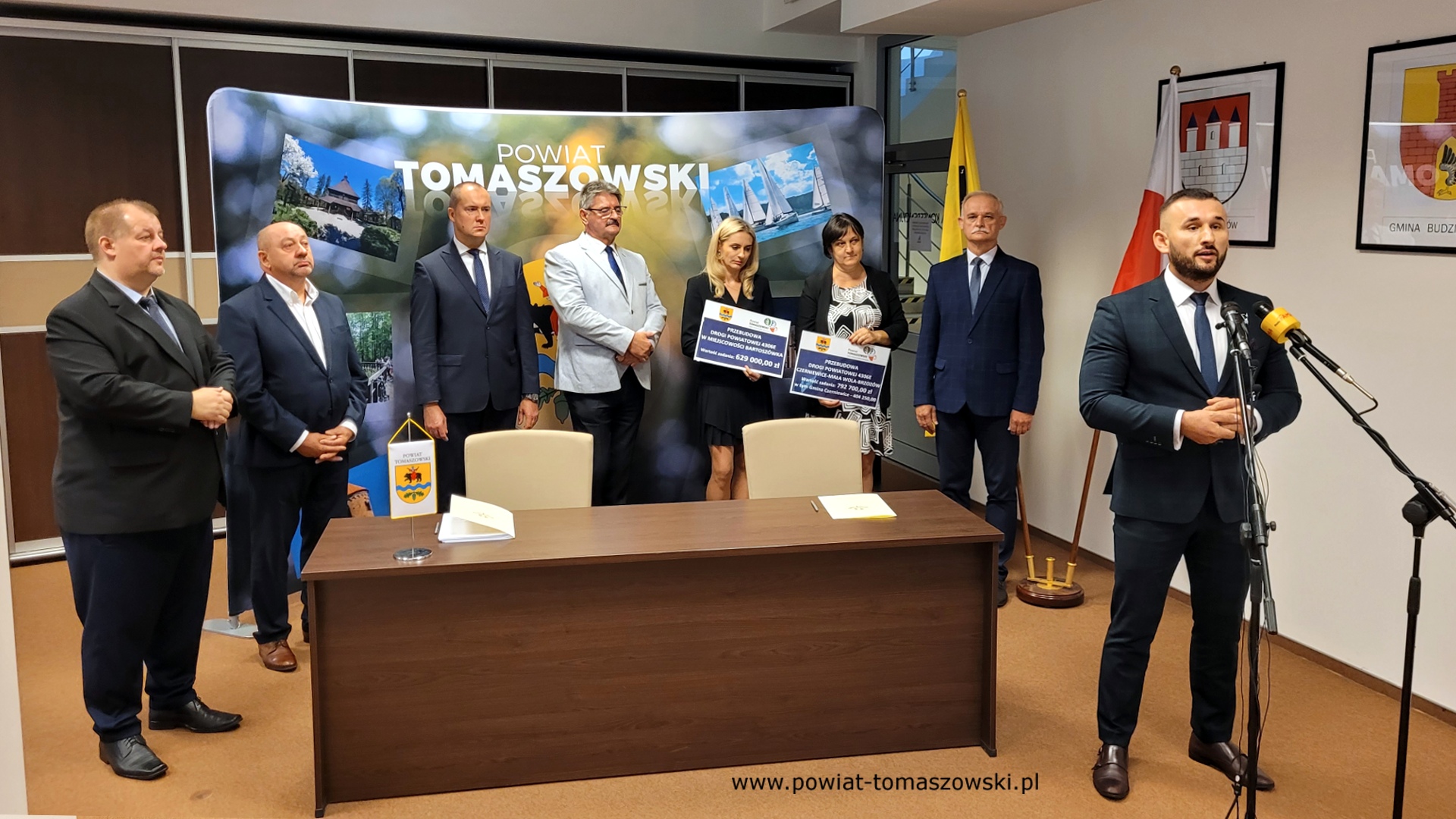 Na zdjęciu: od prawej: Grzegorz Glimasiński – przewodniczący Komisji Bezpieczeństwa Publicznego i Transportu, Włodzimierz Justyna – przewodniczący Komisji Rewizyjnej, Katarzyna Kmita - właściciel Przedsiębiorstwa Handlowo–Usługowego KAMI, Elżbieta Rudzka – dyrektor Zarządu Dróg Powiatowych, Leszek Ogórek – Wicestarosta Powiatu Tomaszowskiego, Michał Czechowicz – członek Zarządu Powiatu Tomaszowskiego, Leon Karwat – przewodniczący Komisji Edukacji, Kultury i Sportu, Mariusz Węgrzynowski – Starosta Powiatu Tomaszowskiego, podczas konferencji prasowej, na której podpisane zostały umowy z wykonawcą, Firmą KAMI, na realizację zadań: Przebudowa układu komunikacyjnego w celu poprawy bezpieczeństwa w ruchu drogi powiatowej nr 4306E w miejscowości Bartoszówka  na odcinku 450 m i zadania: Przebudowa układu komunikacyjnego w celu poprawy bezpieczeństwa w ruchu drogi powiatowej nr 4306E Czerniewice – Mała Wola - Brzozów  na odcinku 990 m.