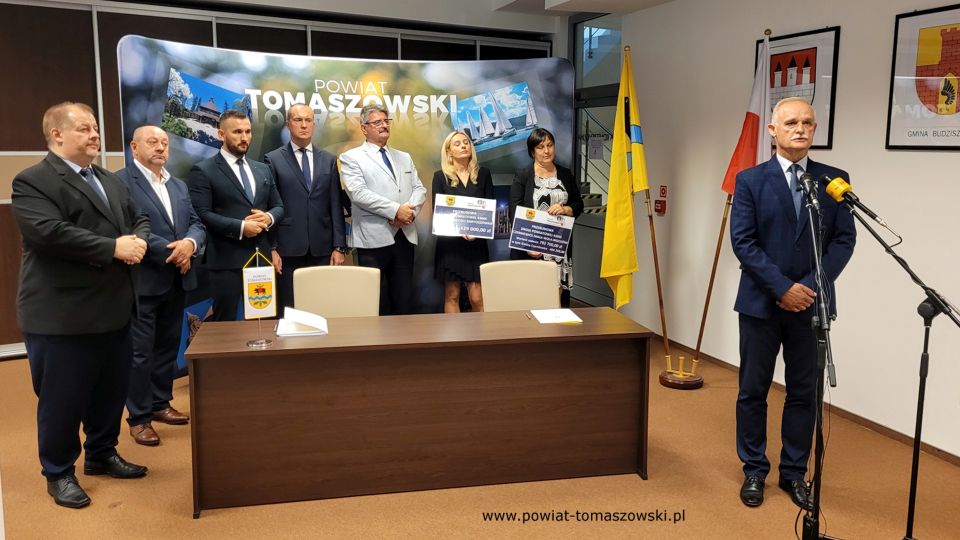Na zdjęciu: od prawej: Włodzimierz Justyna – przewodniczący Komisji Rewizyjnej, Katarzyna Kmita - właściciel Przedsiębiorstwa Handlowo–Usługowego KAMI, Elżbieta Rudzka – dyrektor Zarządu Dróg Powiatowych, Leszek Ogórek – Wicestarosta Powiatu Tomaszowskiego, Michał Czechowicz – członek Zarządu Powiatu Tomaszowskiego, Grzegorz Glimasiński – przewodniczący Komisji Bezpieczeństwa Publicznego i Transportu, Leon Karwat – przewodniczący Komisji Edukacji, Kultury i Sportu, Mariusz Węgrzynowski – Starosta Powiatu Tomaszowskiego, podczas konferencji prasowej, na której podpisane zostały umowy z wykonawcą, Firmą KAMI, na realizację zadań: Przebudowa układu komunikacyjnego w celu poprawy bezpieczeństwa w ruchu drogi powiatowej nr 4306E w miejscowości Bartoszówka  na odcinku 450 m i zadania: Przebudowa układu komunikacyjnego w celu poprawy bezpieczeństwa w ruchu drogi powiatowej nr 4306E Czerniewice – Mała Wola - Brzozów  na odcinku 990 m.