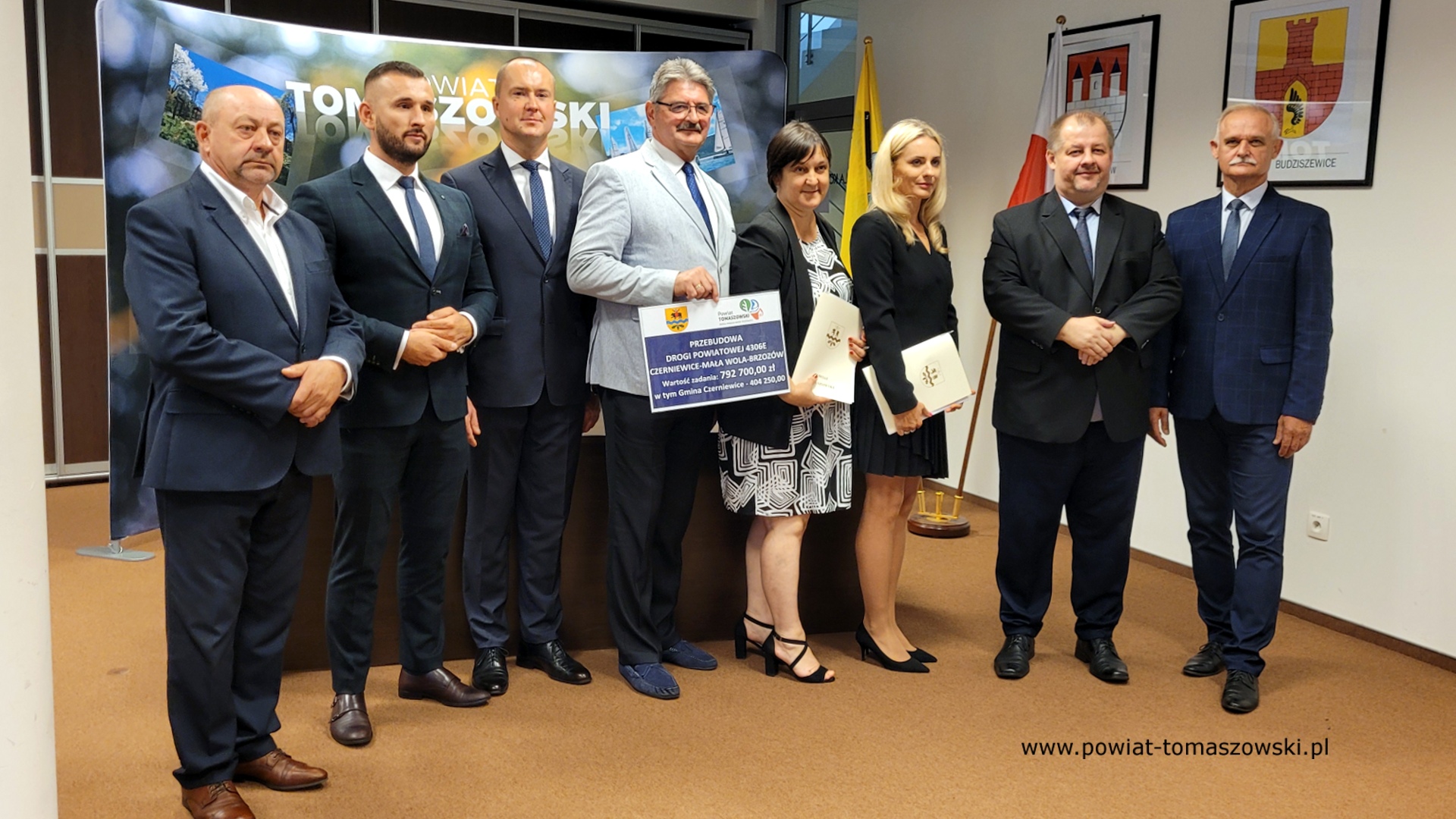 Na zdjęciu: od prawej: Włodzimierz Justyna – przewodniczący Komisji Rewizyjnej, Mariusz Węgrzynowski – Starosta Powiatu Tomaszowskiego, Katarzyna Kmita - właściciel Przedsiębiorstwa Handlowo–Usługowego KAMI, Elżbieta Rudzka – dyrektor Zarządu Dróg Powiatowych, Leszek Ogórek – Wicestarosta Powiatu Tomaszowskiego, Michał Czechowicz – członek Zarządu Powiatu Tomaszowskiego, Grzegorz Glimasiński – przewodniczący Komisji Bezpieczeństwa Publicznego i Transportu, Leon Karwat – przewodniczący Komisji Edukacji, Kultury i Sportu, podczas konferencji prasowej, na której podpisane zostały umowy z wykonawcą, Firmą KAMI, na realizację zadań: Przebudowa układu komunikacyjnego w celu poprawy bezpieczeństwa w ruchu drogi powiatowej nr 4306E w miejscowości Bartoszówka  na odcinku 450 m i zadania: Przebudowa układu komunikacyjnego w celu poprawy bezpieczeństwa w ruchu drogi powiatowej nr 4306E Czerniewice – Mała Wola - Brzozów  na odcinku 990 m.