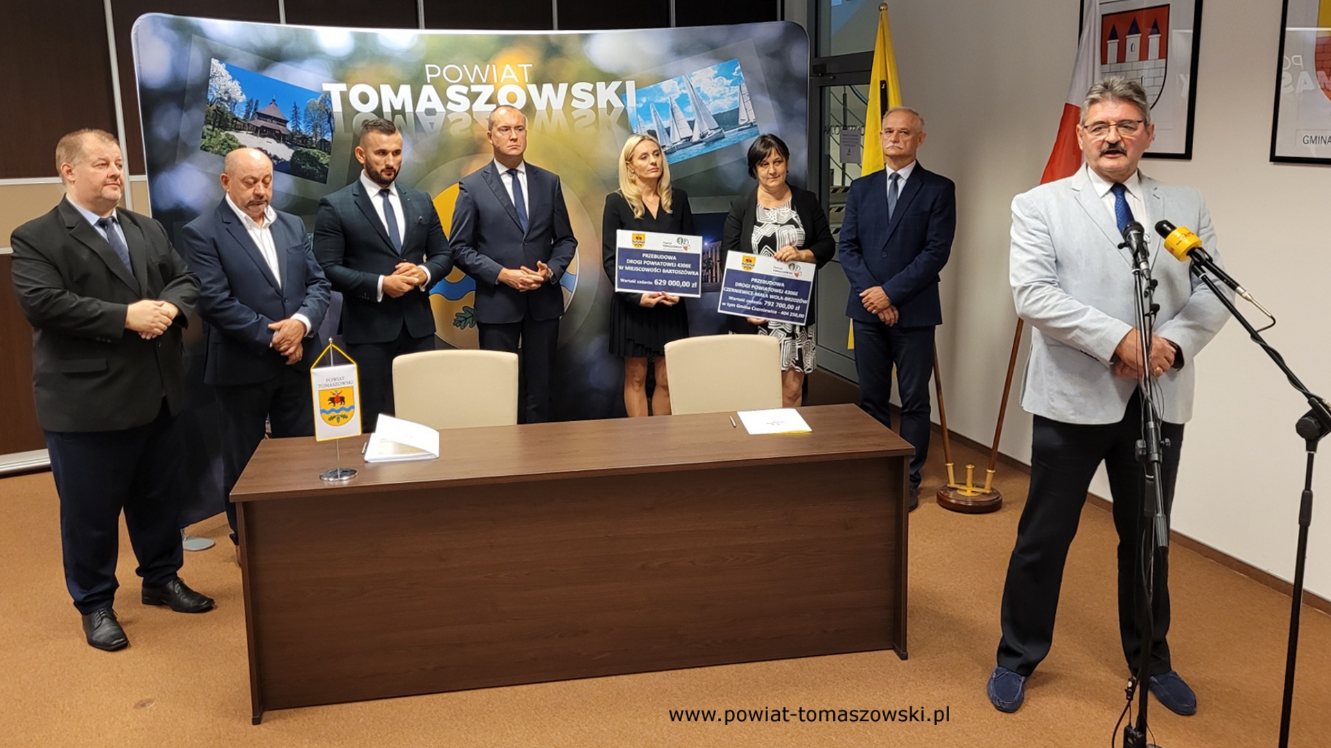 Na zdjęciu: od prawej: Leszek Ogórek – Wicestarosta Powiatu Tomaszowskiego, Włodzimierz Justyna – przewodniczący Komisji Rewizyjnej, Katarzyna Kmita - właściciel Przedsiębiorstwa Handlowo–Usługowego KAMI, Elżbieta Rudzka – dyrektor Zarządu Dróg Powiatowych, Michał Czechowicz – członek Zarządu Powiatu Tomaszowskiego, Grzegorz Glimasiński – przewodniczący Komisji Bezpieczeństwa Publicznego i Transportu, Leon Karwat – przewodniczący Komisji Edukacji, Kultury i Sportu, Mariusz Węgrzynowski – Starosta Powiatu Tomaszowskiego, podczas konferencji prasowej, na której podpisane zostały umowy z wykonawcą, Firmą KAMI, na realizację zadań: Przebudowa układu komunikacyjnego w celu poprawy bezpieczeństwa w ruchu drogi powiatowej nr 4306E w miejscowości Bartoszówka  na odcinku 450 m i zadania: Przebudowa układu komunikacyjnego w celu poprawy bezpieczeństwa w ruchu drogi powiatowej nr 4306E Czerniewice – Mała Wola - Brzozów  na odcinku 990 m.