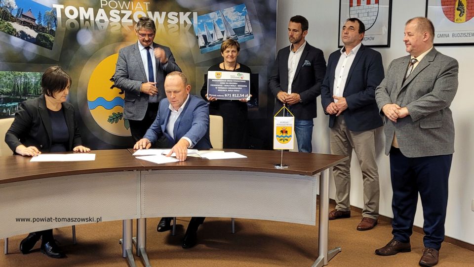 Na zdjęciu: od prawej: Mariusz Węgrzynowski – Starosta Powiatu Tomaszowskiego, Dariusz Kowalczyk – radny Rady Powiatu Tomaszowskiego, Marek Kubiak – członek Zarządu Powiatu Tomaszowskiego, Elżbieta Łojszczyk - członek Zarządu Powiatu Tomaszowskiego, Leszek Ogórek – Wicestarosta Powiatu Tomaszowskiego, siedzą: Elżbieta Rudzka – dyrektor Zarządu Dróg Powiatowych i Ryszard Skoneczny – właściciel FH Agro-Trans z Czerniewic, wykonawca prac, podczas konferencji prasowej, na której podpisana została umowa na realizację zadania pod nazwą: Modernizacja drogi powiatowej 4306E na odcinku Czerniewice – Mała Wola - Brzozów w obrębach miejscowości Dzielnica, Mała Wola, na odcinku 1450 m (500 m w miejscowości Mała Wola, 950 m miejscowości Dzielnica), która odbyła się w środę, 3 listopada 2021 roku, w sali konferencyjnej w Starostwie Powiatowym w Tomaszowie Mazowieckim