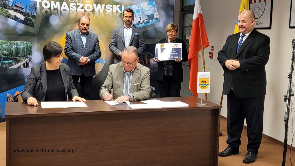 Na zdjęciu: od prawej stoją: Mariusz Węgrzynowski – Starosta Powiatu Tomaszowskiego, powitał uczestników konferencji: Elżbieta Łojszczyk – członek Zarządu Powiatu Tomaszowskiego, Marek Kubiak – członek Zarządu Powiatu Tomaszowskiego, Jan Balcerek– radny Rady Powiatu Tomaszowskiego, siedzą: Elżbieta Rudzka – dyrektor Zarządu Dróg Powiatowych i Marek Kijanowicz – dyrektor naczelny Przedsiębiorstwa Budowy Dróg i Mostów ERBADIM Sp. Z o.o. z Piotrkowa Trybunalskiego – wykonawca zadania, podczas podpisania umowy na realizację zadania pod nazwą: „Modernizacja drogi powiatowej numer 4319E Ujazd – Janków”