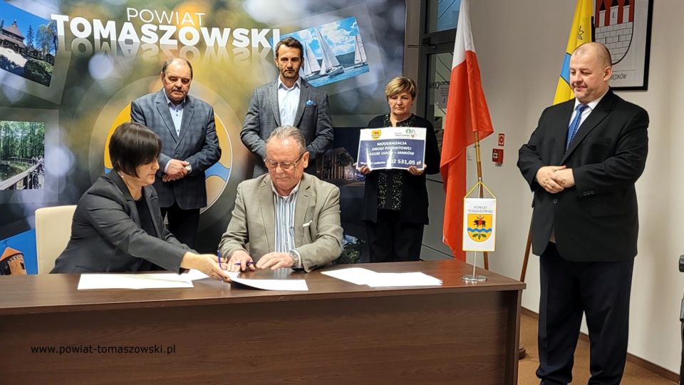 Na zdjęciu: od prawej stoją: Mariusz Węgrzynowski – Starosta Powiatu Tomaszowskiego, powitał uczestników konferencji: Elżbieta Łojszczyk – członek Zarządu Powiatu Tomaszowskiego, Marek Kubiak – członek Zarządu Powiatu Tomaszowskiego, Jan Balcerek– radny Rady Powiatu Tomaszowskiego, siedzą: Elżbieta Rudzka – dyrektor Zarządu Dróg Powiatowych i Marek Kijanowicz – dyrektor naczelny Przedsiębiorstwa Budowy Dróg i Mostów ERBADIM Sp. Z o.o. z Piotrkowa Trybunalskiego – wykonawca zadania, podczas podpisania umowy na realizację zadania pod nazwą: „Modernizacja drogi powiatowej numer 4319E Ujazd – Janków”