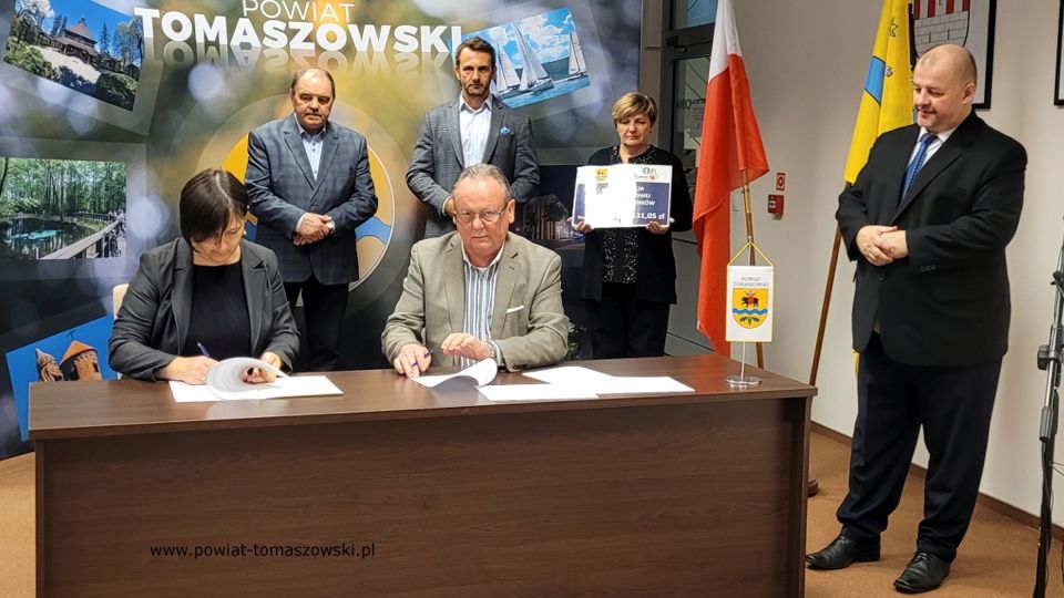 Na zdjęciu: od prawej stoją: Mariusz Węgrzynowski – Starosta Powiatu Tomaszowskiego, powitał uczestników konferencji: Elżbieta Łojszczyk – członek Zarządu Powiatu Tomaszowskiego, Marek Kubiak – członek Zarządu Powiatu Tomaszowskiego, Jan Balcerek– radny Rady Powiatu Tomaszowskiego, siedzą: Elżbieta Rudzka – dyrektor Zarządu Dróg Powiatowych i Marek Kijanowicz – dyrektor naczelny Przedsiębiorstwa Budowy Dróg i Mostów ERBADIM Sp. Z o.o. z Piotrkowa Trybunalskiego – wykonawca zadania, podczas podpisania umowy na realizację zadania pod nazwą: „Modernizacja drogi powiatowej numer 4319E Ujazd – Janków”