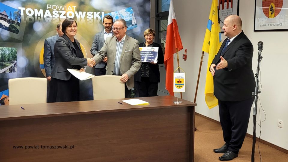 Na zdjęciu: od prawej stoją: Mariusz Węgrzynowski – Starosta Powiatu Tomaszowskiego, powitał uczestników konferencji: Elżbieta Łojszczyk – członek Zarządu Powiatu Tomaszowskiego, Marek Kubiak – członek Zarządu Powiatu Tomaszowskiego, Jan Balcerek– radny Rady Powiatu Tomaszowskiego, siedzą: Elżbieta Rudzka – dyrektor Zarządu Dróg Powiatowych i Marek Kijanowicz – dyrektor naczelny Przedsiębiorstwa Budowy Dróg i Mostów ERBADIM Sp. Z o.o. z Piotrkowa Trybunalskiego – wykonawca zadania, podczas podpisania umowy na realizację zadania pod nazwą: „Modernizacja drogi powiatowej numer 4319E Ujazd – Janków”