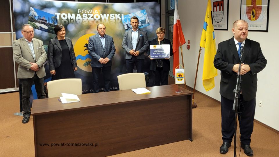 Na zdjęciu: od prawej stoją: Mariusz Węgrzynowski – Starosta Powiatu Tomaszowskiego, powitał uczestników konferencji: Elżbieta Łojszczyk – członek Zarządu Powiatu Tomaszowskiego, Marek Kubiak – członek Zarządu Powiatu Tomaszowskiego, Jan Balcerek– radny Rady Powiatu Tomaszowskiego, siedzą: Elżbieta Rudzka – dyrektor Zarządu Dróg Powiatowych i Marek Kijanowicz – dyrektor naczelny Przedsiębiorstwa Budowy Dróg i Mostów ERBADIM Sp. Z o.o. z Piotrkowa Trybunalskiego – wykonawca zadania, podczas podpisania umowy na realizację zadania pod nazwą: „Modernizacja drogi powiatowej numer 4319E Ujazd – Janków”