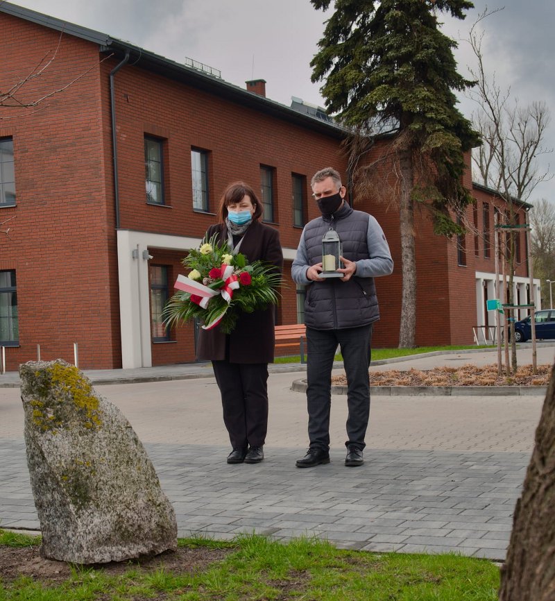 Na zdjęciu: Dorota Ignasiak – dyrektor Powiatowego Centrum Animacji Społecznej w Tomaszowie Mazowiecki i Dariusz Stańdo – wicedyrektor PCAS-u, składają kwiaty 13 kwietnia 2021 roku, w Dzień Pamięci Ofiar Zbrodni Katyńskiej, pod Dębem Pamięci Antoniego Małka, nauczyciela zamordowanego w Katyniu. Dąb Pamięci znajduje się na terenie PCAS-u przy ulicy Farbiarskiej