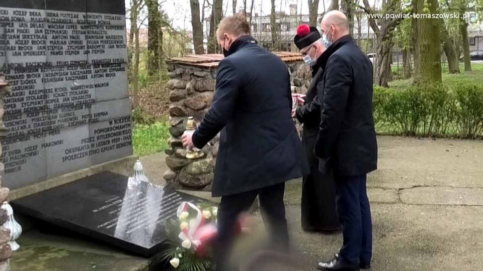 Na zdjęciu: delegacja w składzie: Dariusz Misztal – Wójt Gminy Będków, Jarosław Błoch – Przewodniczący Rady Gminy Będków, ksiądz Krzysztof Nowak – proboszcz parafii Narodzenia Najświętszej Maryi Panny w Będkowie, składają kwiaty pod tablicą Błażeja Stolarskiego w Będkowie w 230. rocznicę uchwalenia Konstytucji 3 Maja