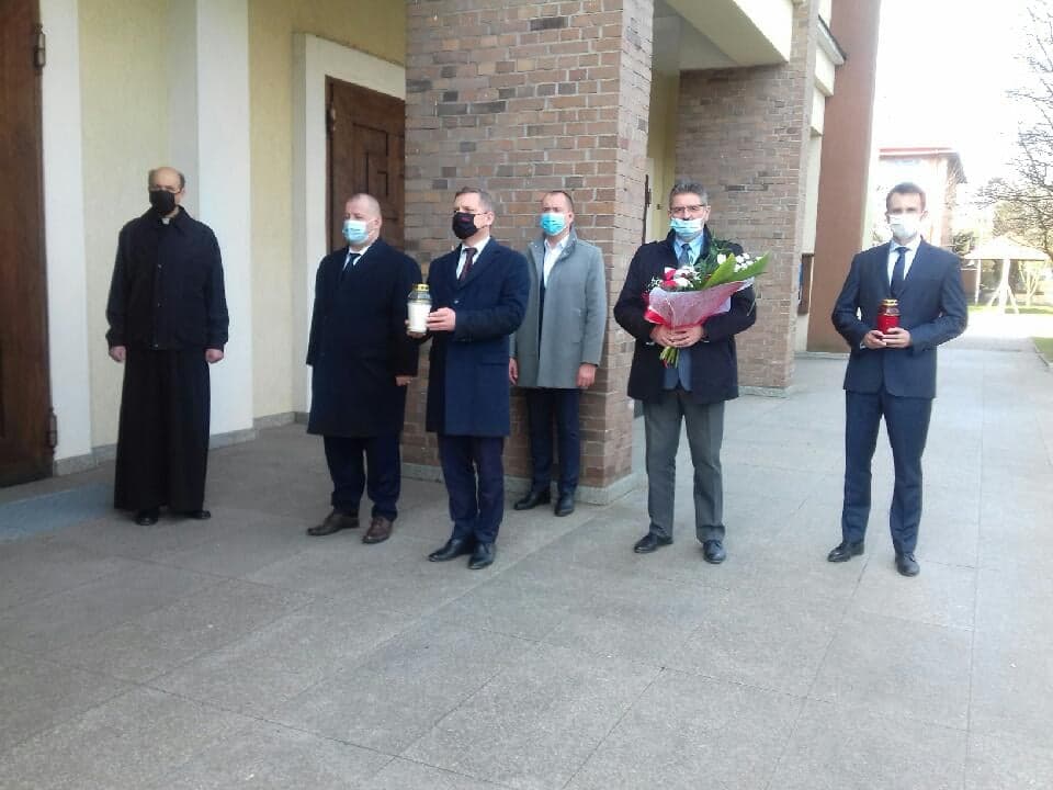Na zdjęciu: delegacja władz samorządowych Województwa Łódzkiego i Powiatu Tomasszowskiego w składzie: od prawej: Marek Kubiak – członek Zarządu Powiatu Tomaszowskiego, Leszek Ogórek – Wicestarosta Powiatu Tomaszowskiego, Michał Czechowicz – członek Zarządu Powiatu Tomaszowskiego, Zbigniew Ziemba – Wicemarszałek Województwa Łódzkiego, Mariusz Węgrzynowski – Starosta Powiatu Tomaszowskiego, ksiądz Jan Cholewa – proboszcz parafii Świętej Jadwiigi w Tomaszowie Mazowieckim, podczas składania kwiatów  pod tablicami „W hołdzie Prezydentowi Rzeczypospolitej Polskiej Profesorowi Lechowi Kaczyńskiemu                     i jego Małżonce Marii” i „W hołdzie ostatniemu Prezydentowi RP na Uchodźstwie Ryszardowi Kaczorowskiemu”, które znajdują się przy wejściu do kościoła pw. św. Jadwigi Królowej w Tomaszowie Maz.