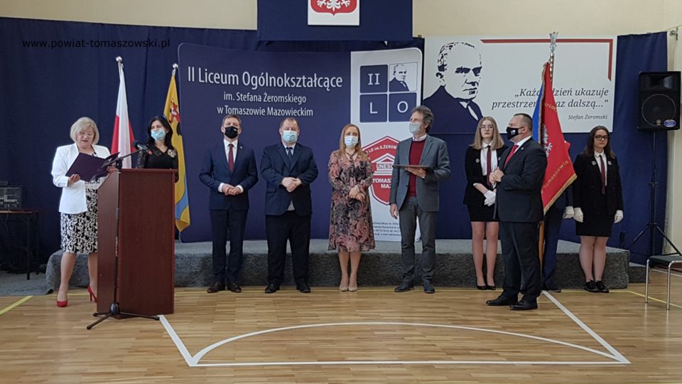 Na zdjęciu: od lewej: Anna Rożej – Wicedyrektor II LO w Tomaszowie Mazowieckim, Beata Stańczyk - Wiceprzewodnicząca Rady Miejskiej i Naczelnik Wydziału Oświaty i Sportu Starostwa Powiatowego w Tomaszowie Mazowieckim, Zbigniew Ziemba – Wicemarszałek Województwa Łódzkiego, Mariusz Węgrzynowski – Starosta Powiatu Tomaszowskiego, Marzena Piotroska-Wąs – nauczyciel II LO, Krzysztof Krajewski – Przewodniczący Rady Rodziców, Arkadiusz Broniarek – dyrektor II LO w Tomaszowie Mazowieckim, z tyłu poczet sztandarowy uczniów II LO z klasy IIe, podczas wręczenia świadectw maturzystom II Liceum w roku szkolnym 2020/2021