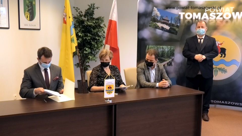 Na zdjęciu:  stoi Mariusz Węgrzynowski – Starosta Powiatu Tomaszowskiego, za biurkiem: Paweł Siminiak – właściciel Przedsiębiorstwa Budowlanego Pagma-Bud, Elżbieta Łojszczyk - członek Zarządu Powiatu Tomaszowskiego, Marek Kubiak – członek Zarządu Powiatu Tomaszowskiego,  podczas podpisania umowy z wykonawcą zadania pn. „Adaptacja budynku położonego na terenie Specjalnego Ośrodka Szkolno-Wychowawczego w Tomaszowie Mazowieckim z przeznaczeniem na rehabilitację zawodową i społeczną osób niepełnosprawnych”
