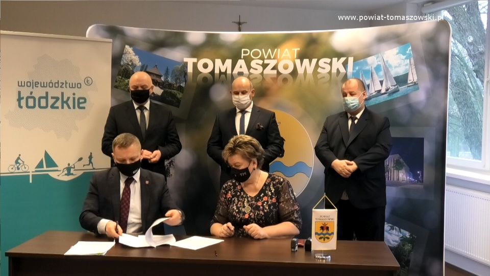 Na zdjęciu: umowę podpisują Wacława Bąk – Przewodnicząca Rady Powiatu Tomaszowskiego i Prezes Tomaszowskiego Towarzystwa Budownictwa Społecznego i Zbigniew Ziemba – Wicemarszałek Województwa Łódzkiego, z tyłu od prawej: Mariusz Węgrzynowski – Starosta Powiatu Tomaszowskiego, Marcin Witko – Prezydent Tomaszowa Mazowieckiego, Janusz Ciesielski – radny Sejmiku Województwa Łódzkiego,  podczas podpisania umowy na dofinansowanie projektu Termomodernizacja budynku przy ulicy Piłsudskiego 17/19 w Tomaszowie Mazowieckim