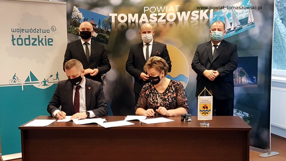 Na zdjęciu: umowę podpisują Wacława Bąk – Przewodnicząca Rady Powiatu Tomaszowskiego i Prezes Tomaszowskiego Towarzystwa Budownictwa Społecznego i Zbigniew Ziemba – Wicemarszałek Województwa Łódzkiego, z tyłu od prawej: Mariusz Węgrzynowski – Starosta Powiatu Tomaszowskiego, Marcin Witko – Prezydent Tomaszowa Mazowieckiego, Janusz Ciesielski – radny Sejmiku Województwa Łódzkiego,  podczas podpisania umowy na dofinansowanie projektu Termomodernizacja budynku przy ulicy Piłsudskiego 17/19 w Tomaszowie Mazowieckim