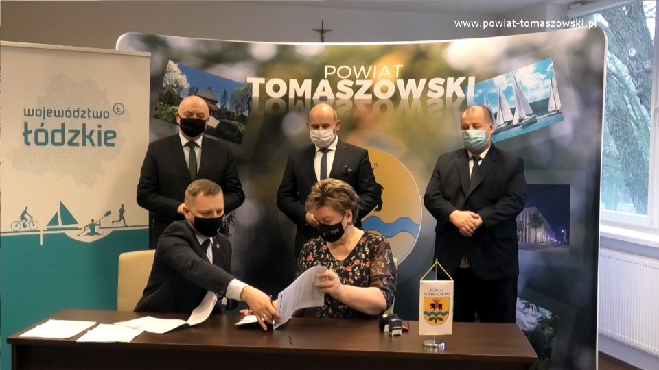 Na zdjęciu: umowę podpisują Wacława Bąk – Przewodnicząca Rady Powiatu Tomaszowskiego i Prezes Tomaszowskiego Towarzystwa Budownictwa Społecznego i Zbigniew Ziemba – Wicemarszałek Województwa Łódzkiego, z tyłu od prawej: Mariusz Węgrzynowski – Starosta Powiatu Tomaszowskiego, Marcin Witko – Prezydent Tomaszowa Mazowieckiego, Janusz Ciesielski – radny Sejmiku Województwa Łódzkiego,  podczas podpisania umowy na dofinansowanie projektu Termomodernizacja budynku przy ulicy Piłsudskiego 17/19 w Tomaszowie Mazowieckim